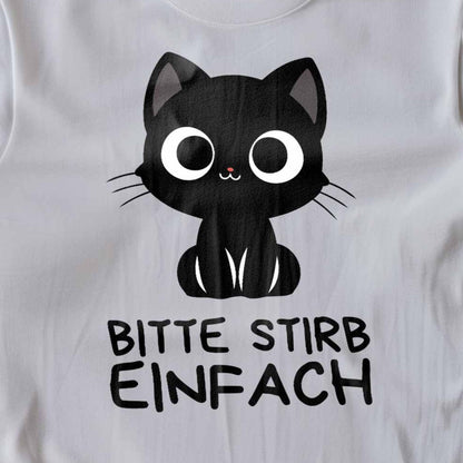 Nahaufnahme eines weißen T-Shirts auf Holzboden mit Design einer süßen schwarzen Katze und dem lustigen Spruch 'Bitte stirb einfach'