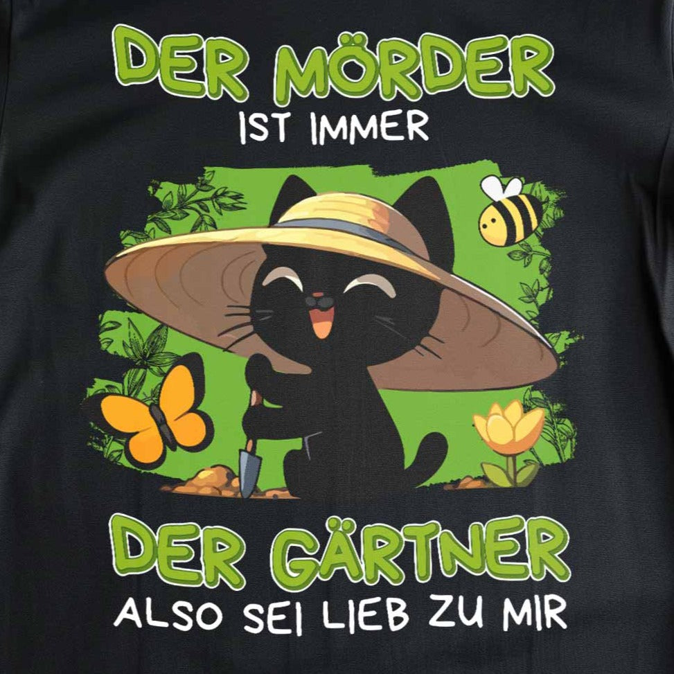 Nahaufnahme eines schwarzen T-Shirts mit Design einer schwarzen Katze und dem lustigen Spruch 'Der Mörder ist immer der Gärtner, also sei lieb zu mir'