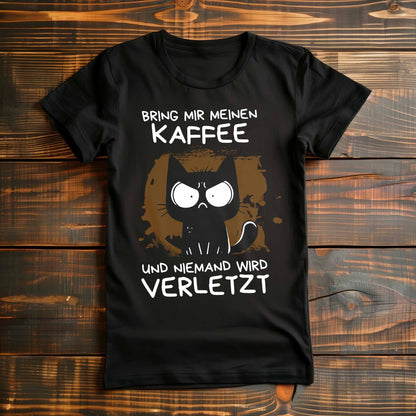 Schwarzes Damen-Shirt auf Holzboden mit Katze und Spruch 'Bring mir meinen Kaffee und niemand wird verletzt'