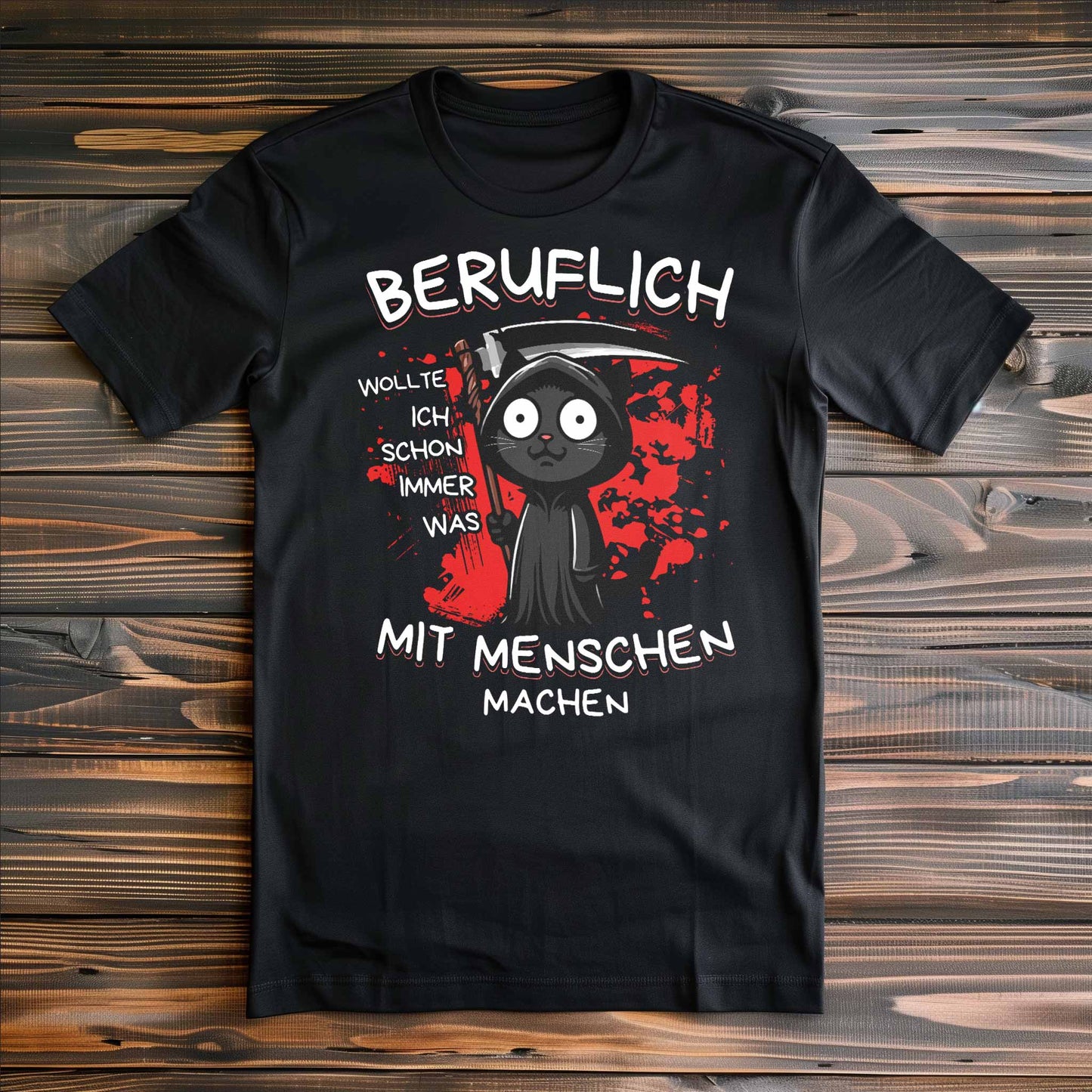 Schwarzes T-Shirt auf Holzboden mit Design einer schwarzen Katze verkleidet als Sensenmann mit Sense und dem lustigen Spruch 'Beruflich wollte ich schon immer was mit Menschen machen'