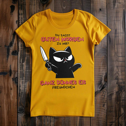 Gelbes Damen-T-Shirt auf Holzboden mit Design einer schwarzen Katze mit Messer und dem lustigen Spruch 'Guten Morgen? Ganz dünnes Eis'