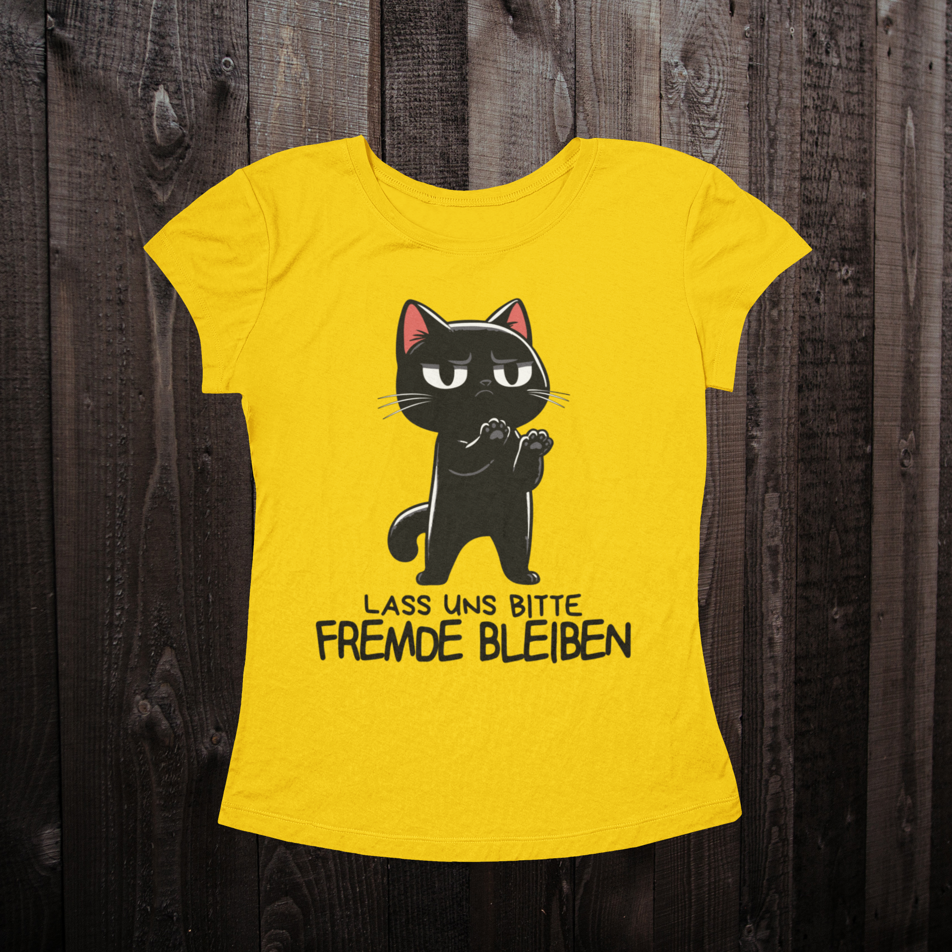 Gelbes T-Shirt für Frauen auf einem dunklen Holzboden mit einer schwarzen Katze als Design und dem lustigen Spruch 'Lass uns bitte Fremde bleiben'