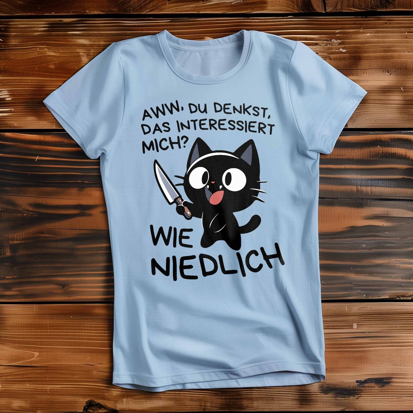 Himmel-Blaues Damen T-Shirt auf Holzboden mit einem witzigen Katzen-Design und dem lustigen Spruch 'Aww, du denkst, das interessiert mich? Wie niedlich'