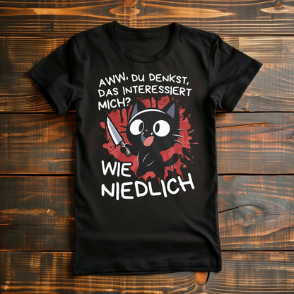 Schwarzes Damen T-Shirt auf Holzboden mit einem witzigen Katzen-Design und dem lustigen Spruch 'Aww, du denkst, das interessiert mich? Wie niedlich'