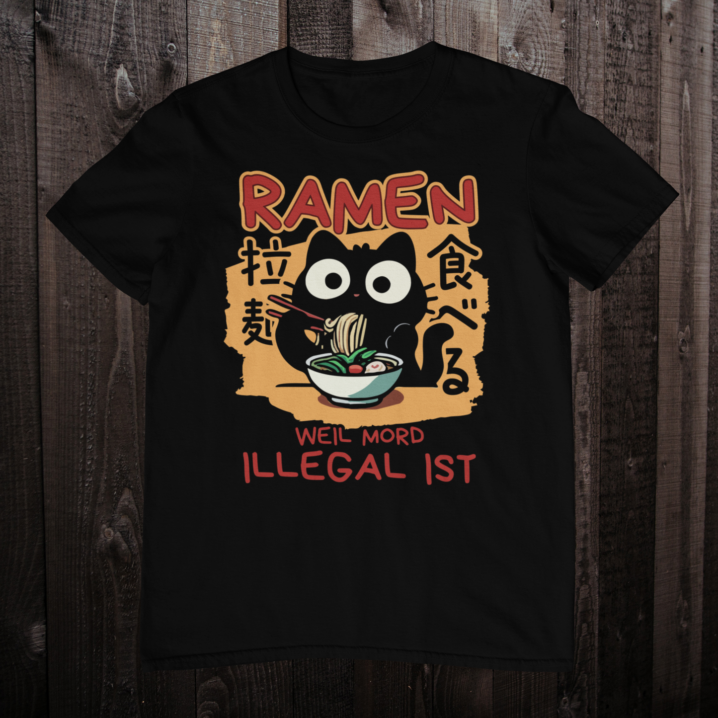 Schwarzes T-Shirt auf Holzboden mit einer süßen schwarzen Kawaii Katze, die Ramen isst, japanischen Schriftzeichen und dem Spruch 'Ramen - Weil Mord illegal ist'