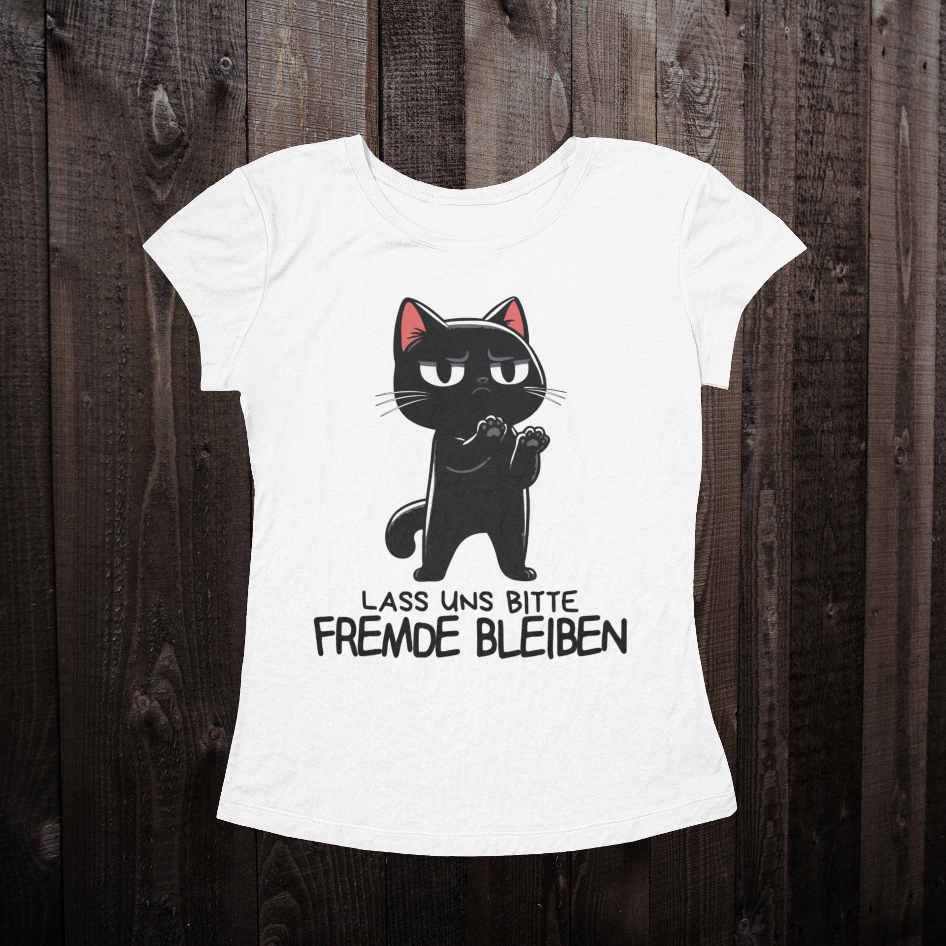 Weißes T-Shirt für Frauen auf einem dunklen Holzboden mit einer schwarzen Katze als Design und dem lustigen Spruch 'Lass uns bitte Fremde bleiben'